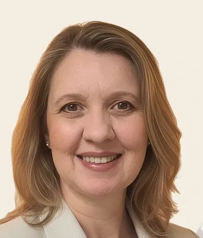 Elaine Lizeo, de blazer claro, sorrindo para a câmera.